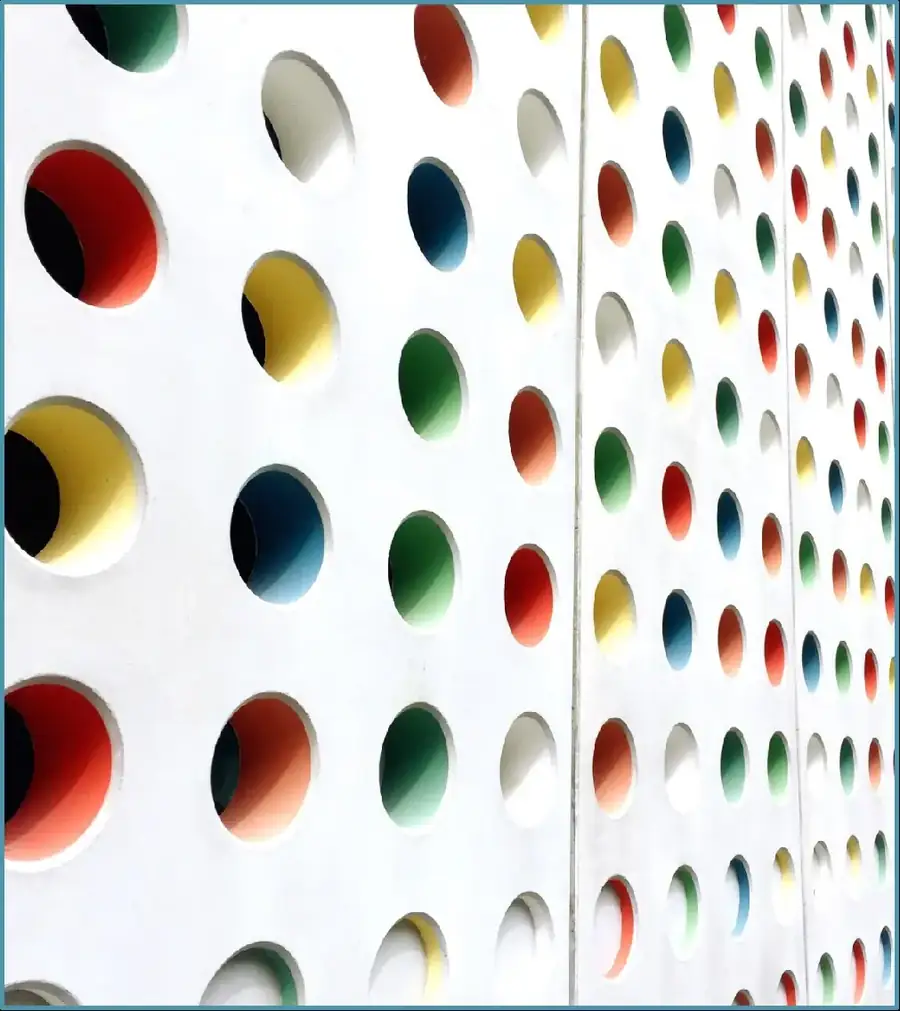 White wall with colorful circular recesses in red, yellow, green and blue